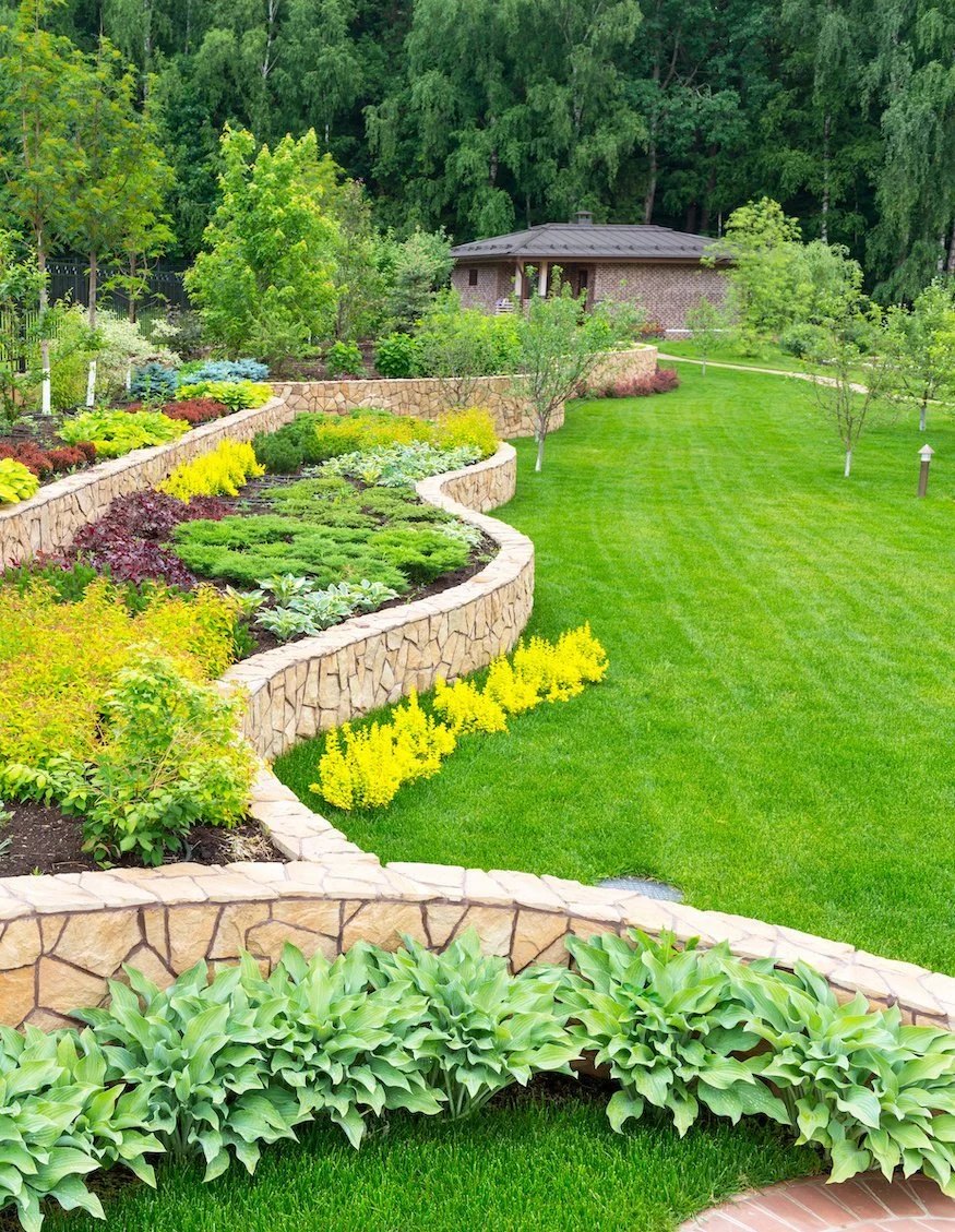 Terraced retaining-wall garden beds beside a manicured lawn