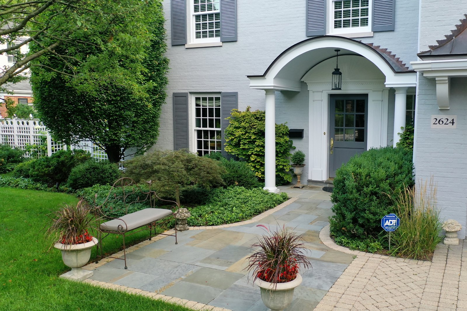 Bluestone walkway with planters and shaped foundation plantings
